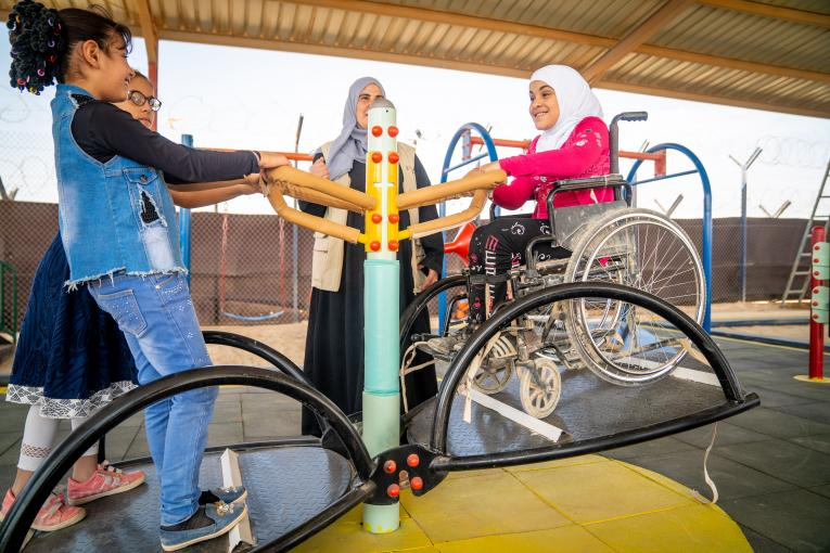 Menina de 9 anos em cadeira de rodas brinca em gangorra no playground inclusivo construído em sua escola, no campo de refugiados de Zaatari, na Jordânia. Foto: UNICEF | Christopher Herwig.